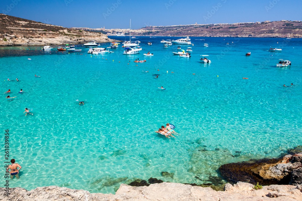 People swiming in blue lagoon at Comino - Malta - obrazy, fototapety, plakaty 