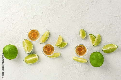 Composition with shots of tequila and lime on white background © Pixel-Shot