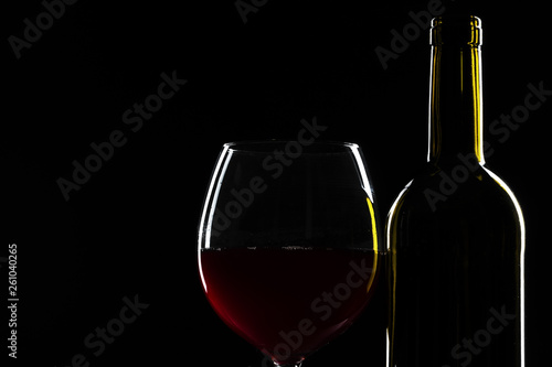  wine bottle and wine glass in a black background