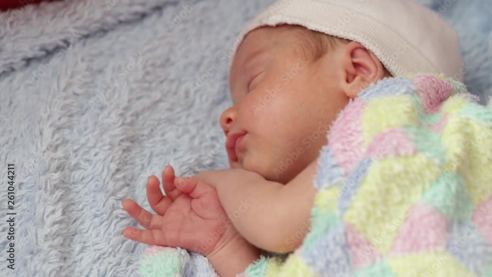 newborn in the first days of life. baby in a hat sleeping in the crib newborn in the first days of life. baby in a hat sleeping in the crib