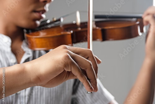 In selectve focus of human hand holding bow,showing how to  play violin,blurry light around
