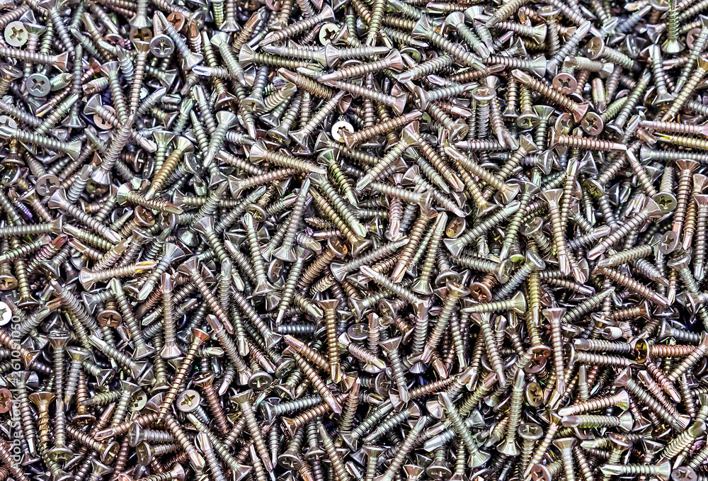 Chrome self-tapping screws on the counter of a hardware store. Background of the self-tapping screws. Chrome self-tapping screws on the counter of a hardware store. Background of the self-tapping screws.