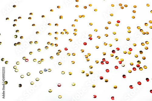 gold sequins scattered on white background