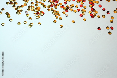 gold sequins scattered on white background