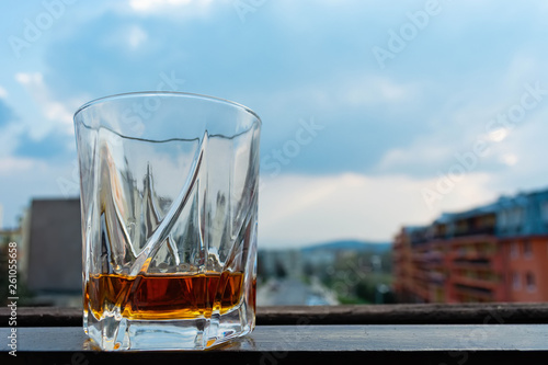 a glass of whiskey against the sky overcast © Oleksandr