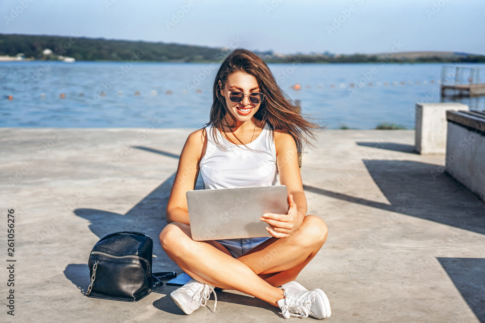 Pretty young girl using laptop outdoor in the city park. Pretty young girl using laptop outdoor in the city park.