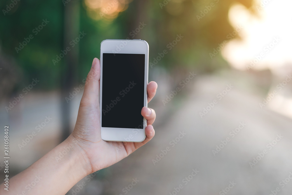 Hand holding smartphone on abstract bokeh background