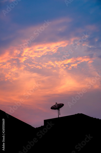Satellite dish on sunset background.