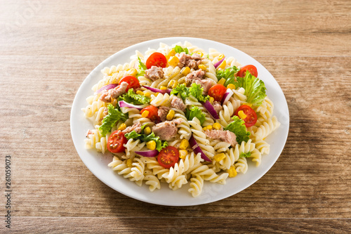Pasta salad with vegetables and tuna on wooden table