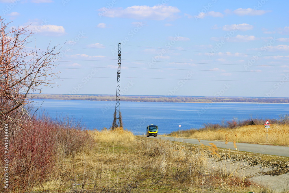 Obraz premium THE BUS GOES ON THE BACKGROUND OF THE RIVER