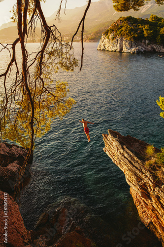jump from stone to a beautiful sea at sunset