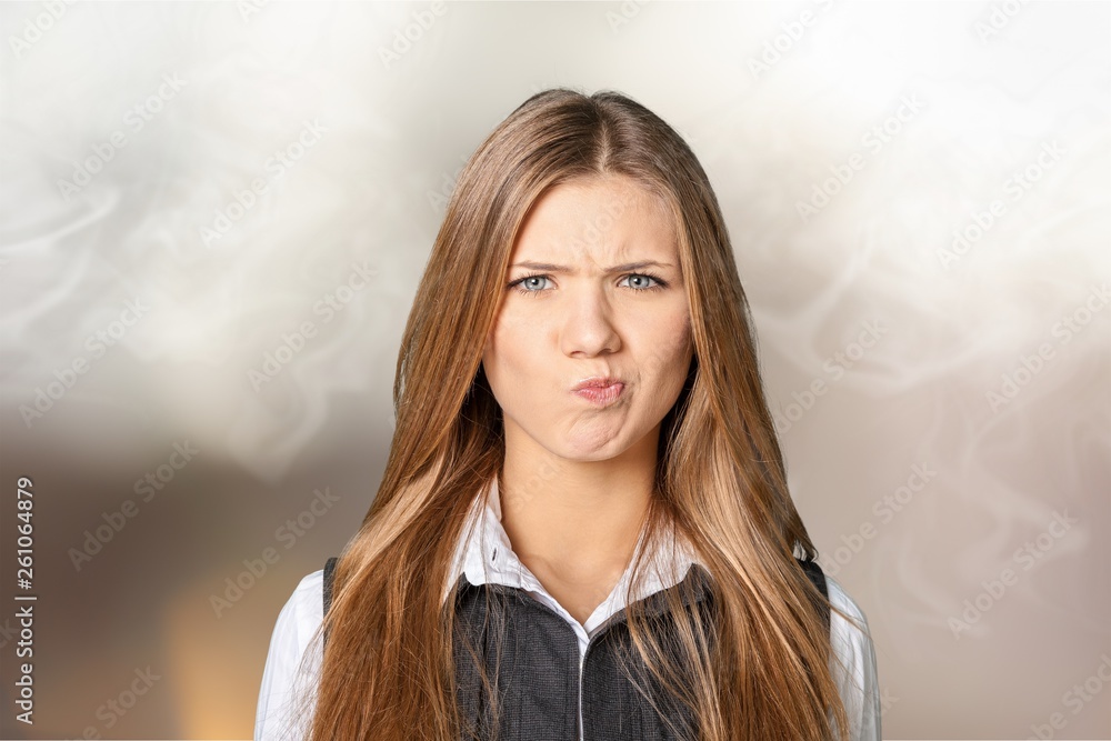 Fototapeta premium Portrait of a young displeased businesswoman on background