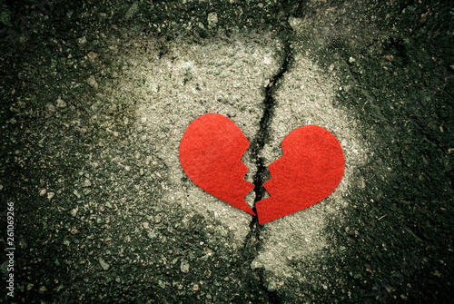 Broken red heart on cracked asphalt. divorce concept.