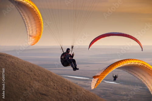Paraglide with a paraglider in a cocoon against the background of fields of the sky and clouds. Paragliding Sports