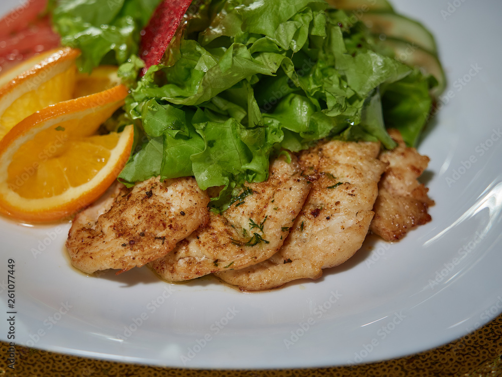 Meat roasted on fire with lemon and green salad. Meat roasted on fire with lemon and green salad.