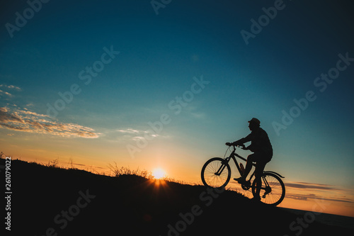 Silhouette of a male mountainbiker at sunset in the mountains