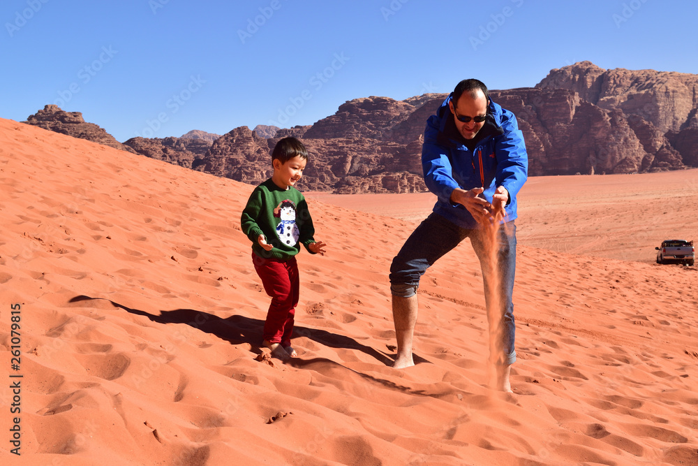 Father and son playing in the sand desert