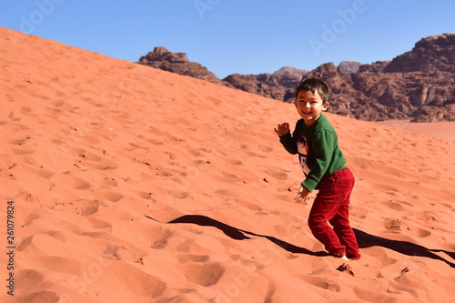 Boy traveling playing in a rose sand desert