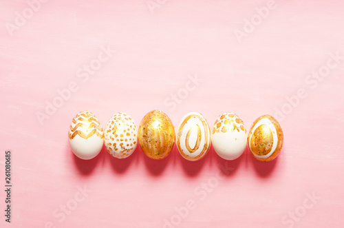 Top view of easter eggs colored with golden paint in differen patterns. Copy space. - Image photo