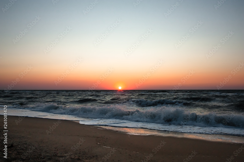 Sea ​​beach at sunrise. Sea ​​waves on a sandy beach. Tropical vacation background. Natural landscape. Sunset ocean horizon sky landscape. Blue ocean waves. Colorful ocean beach sunrise.
