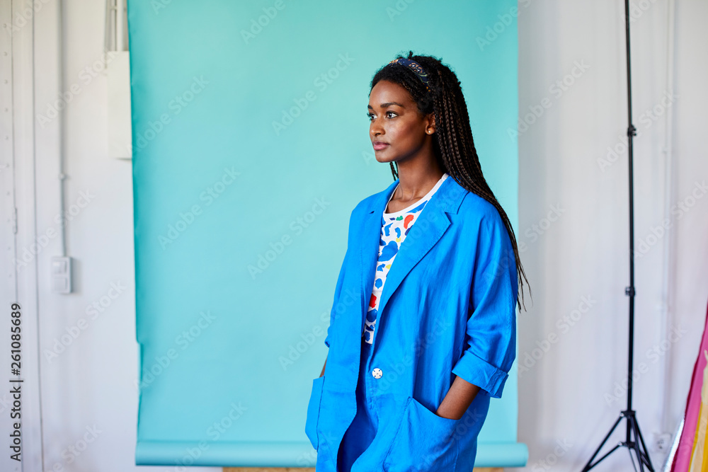 Confident Executive Standing Against Blue Backdrop Confident Executive Standing Against Blue Backdrop