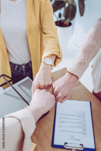 cropped view of supportive group giving fist bump in office