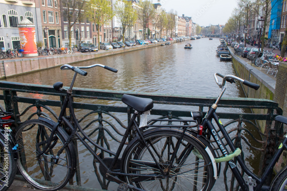 Amsterdam/Netherlands, April 06, 2019: Old streets along numerous canals in Amsterdam. River transport and bicycles