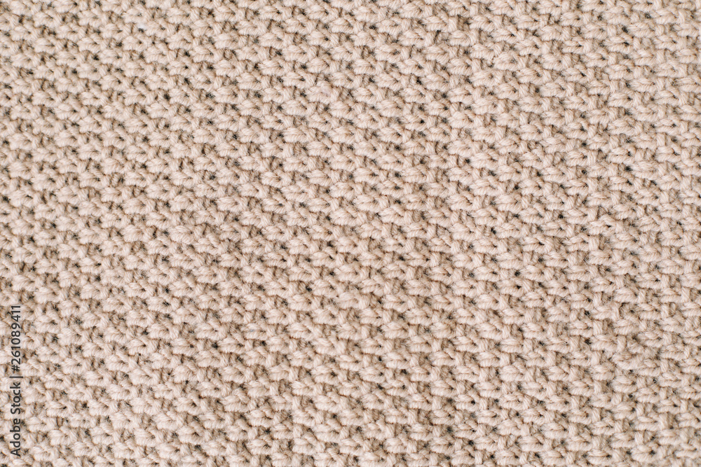 Knitted background. Knitting pattern of wool. Knitting. Texture of knitted woolen  fabric for wallpaper and an abstract background