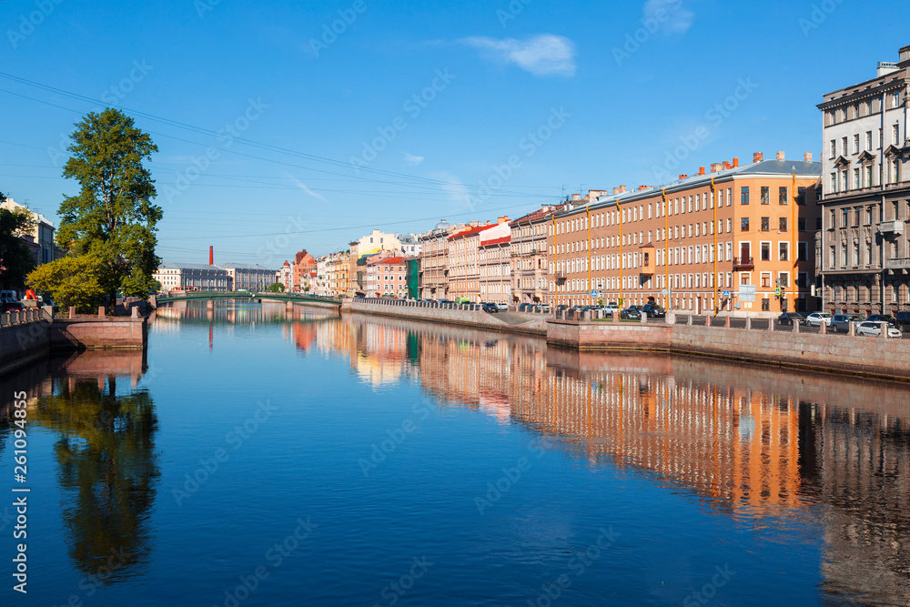 View of the Fontanka river with with English bridge in the distance, profitable houses on the waterfront and their mirror image in the water. Saint Petersburg, Russia