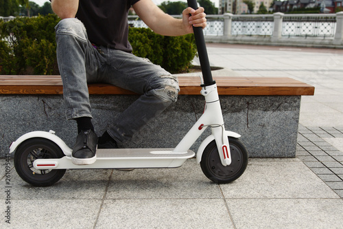 Crop man with scooter on bench photo