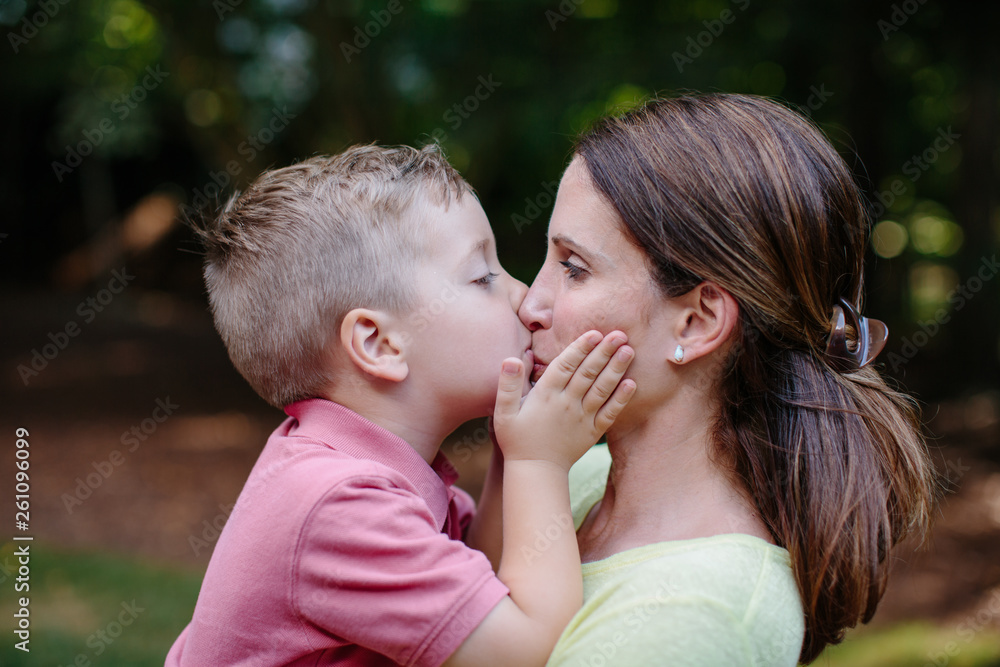 Cute young boy giving his mother an affectionate kiss on the mouth Cute young boy giving his mother an affectionate kiss on the mouth