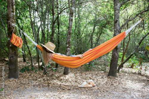 Person taking a nap in a hammock in the woods photo