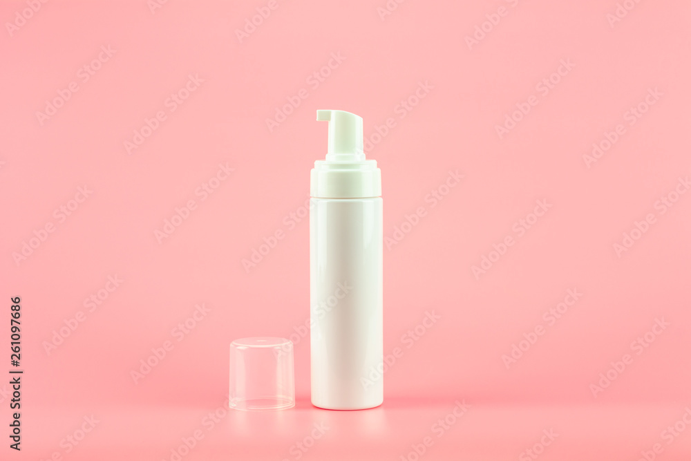 White plastic cosmetic lotion bottle on pink background. White plastic cosmetic lotion bottle on pink background.