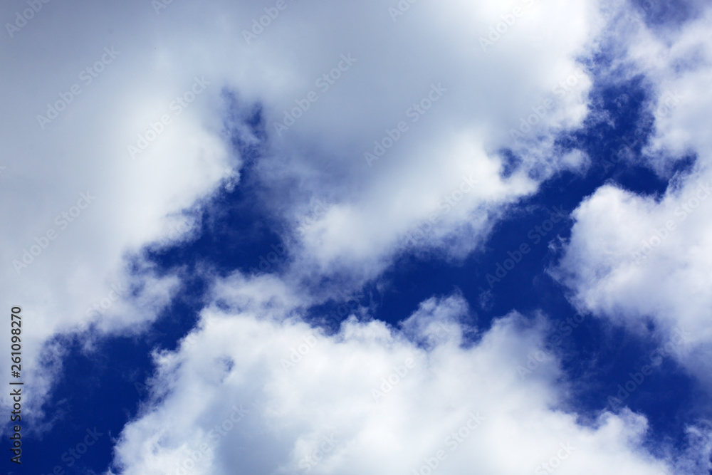 Obraz premium Big white fluffy clouds in the blue sky.Summer background.