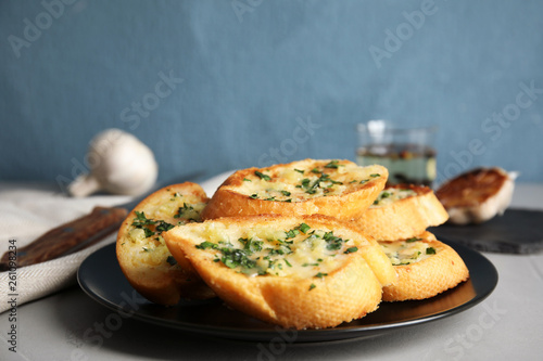 Plate with delicious homemade garlic bread on table, closeup. Space for text