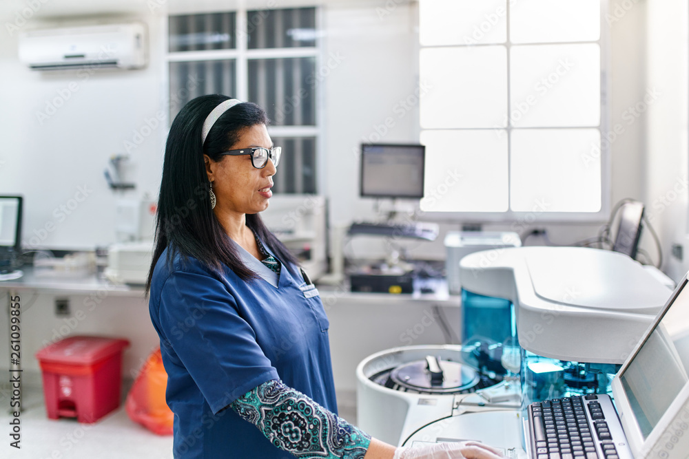 Technician at medical analyzer machine Technician at medical analyzer machine