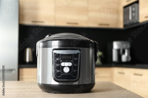 Modern multi cooker on wooden table in kitchen