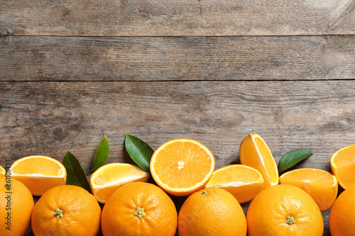 Flat lay composition with ripe oranges and space for text on wooden background
