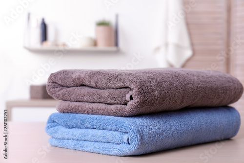 Stack of fresh towels on table in bathroom