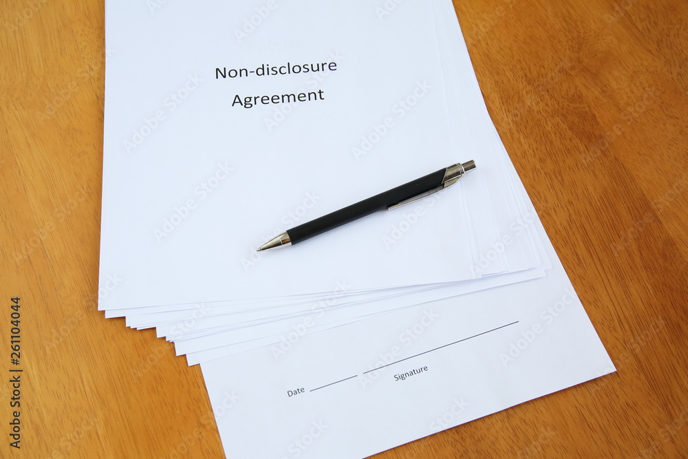 Non-disclosure agreement and pen on wooden table Non-disclosure agreement and pen on wooden table