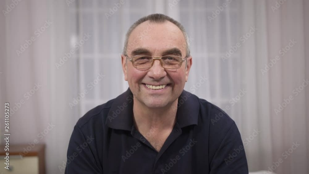 An elderly man with glasses smiles. On face smile joy and happiness An elderly man with glasses smiles. On face smile joy and happiness