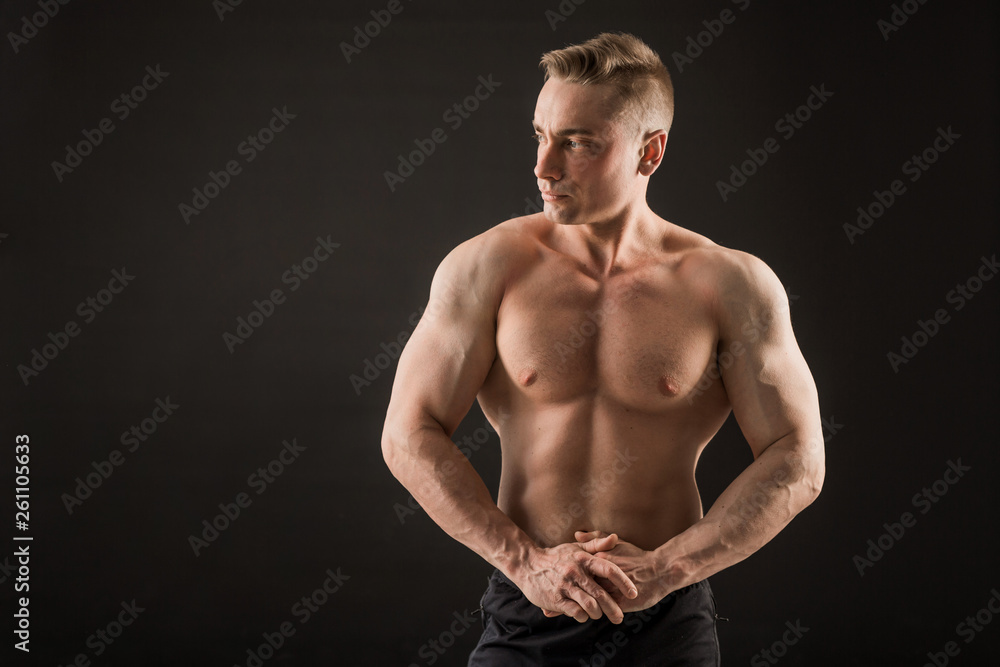 handsome man with muscles on a black background handsome man with muscles on a black background