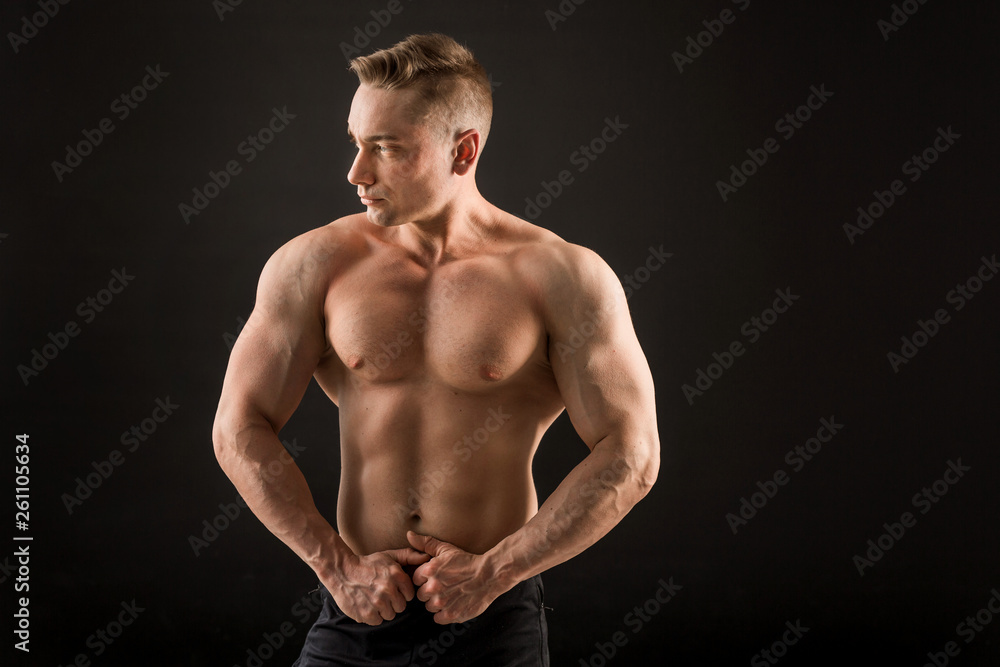 handsome man with muscles on a black background handsome man with muscles on a black background