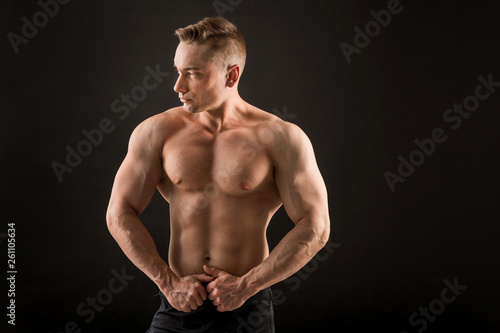 handsome man with muscles on a black background © Alexandr