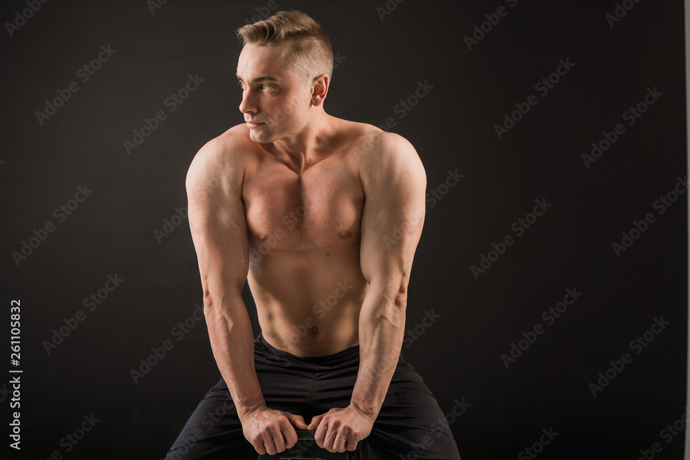 handsome man with muscles on a black background handsome man with muscles on a black background