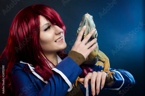 cosplay anime girl and green iguana in studio. halloween