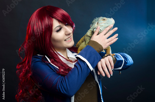 cosplay anime girl and green iguana in studio. halloween