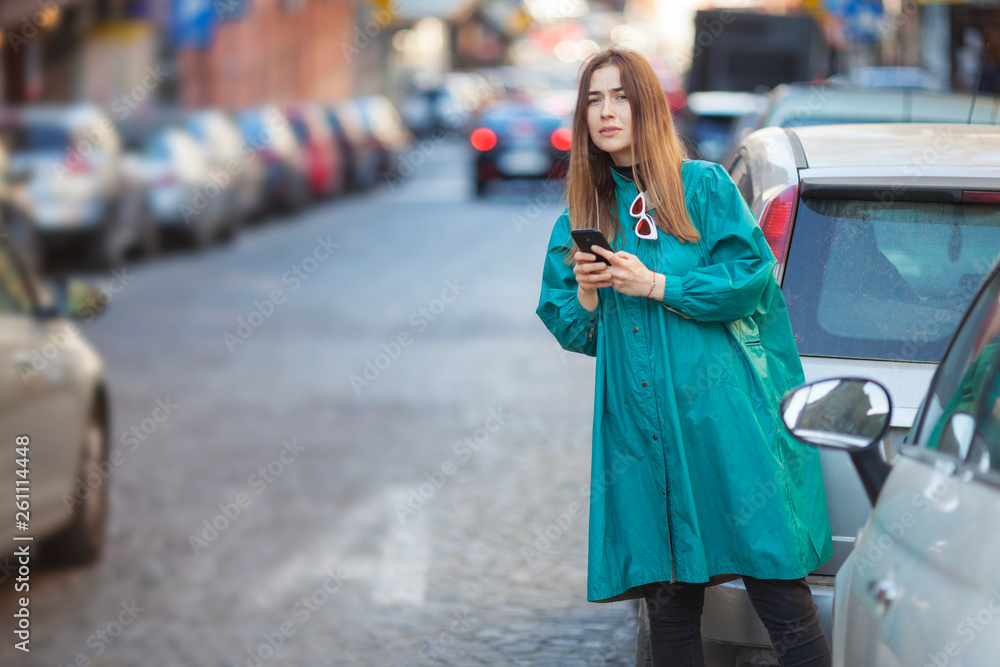 young woman using a mobile phone application to call for a taxi