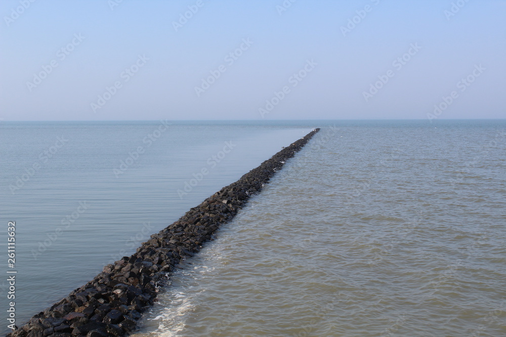 Opposites: the water breaks on one side, the other is quiet with running water in the Wadden Sea