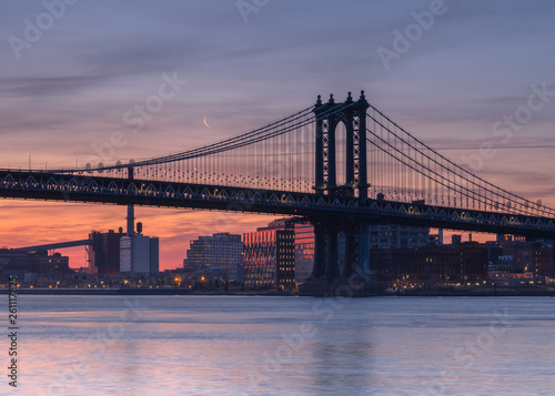 Manhattan bridge with the moon from East River at sunrise 